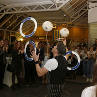 Der Künstler Eddy Carello jongliert mit drei Ringen und zwei Bällen